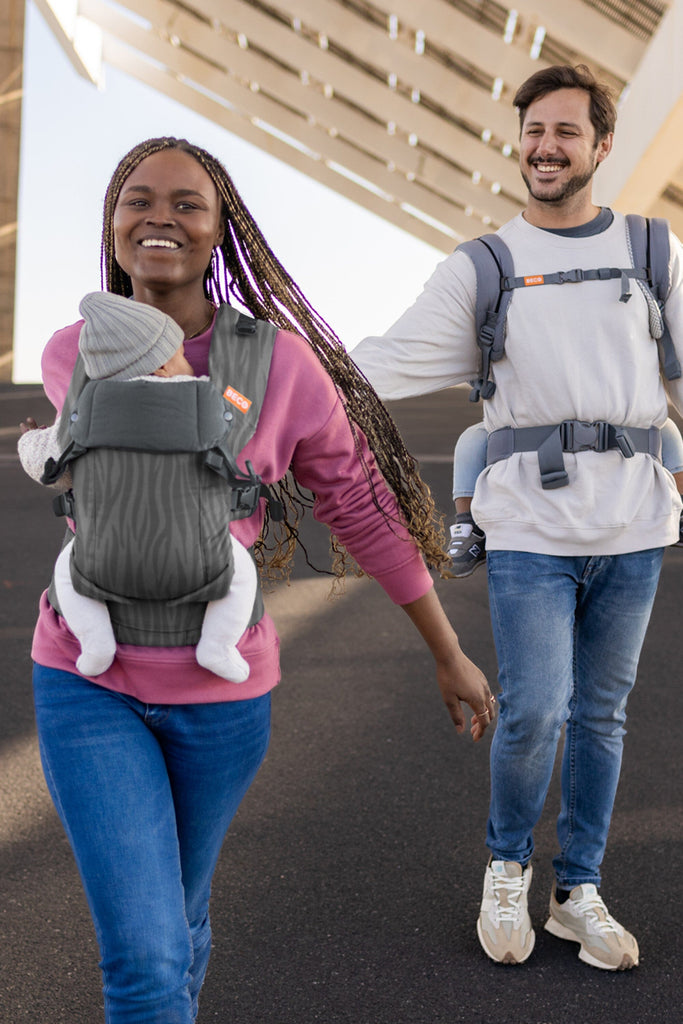 Baby front carry facing in in the Beco Gemini baby carrier in dark zebra pattern