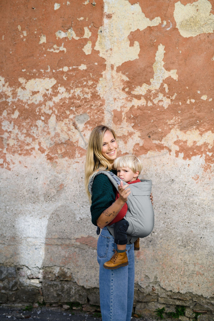 Beco Toddler Carrier in grey, shown with toddler in the front carry position