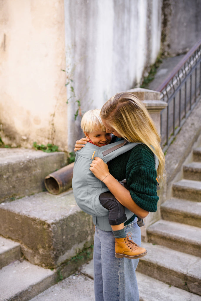 Beco Toddler Carrier in grey, shown with toddler in the front carry position