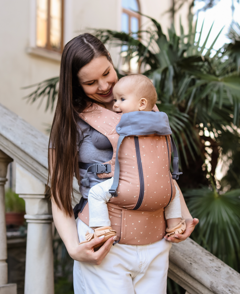 Smiling baby in a pink Beco carrier