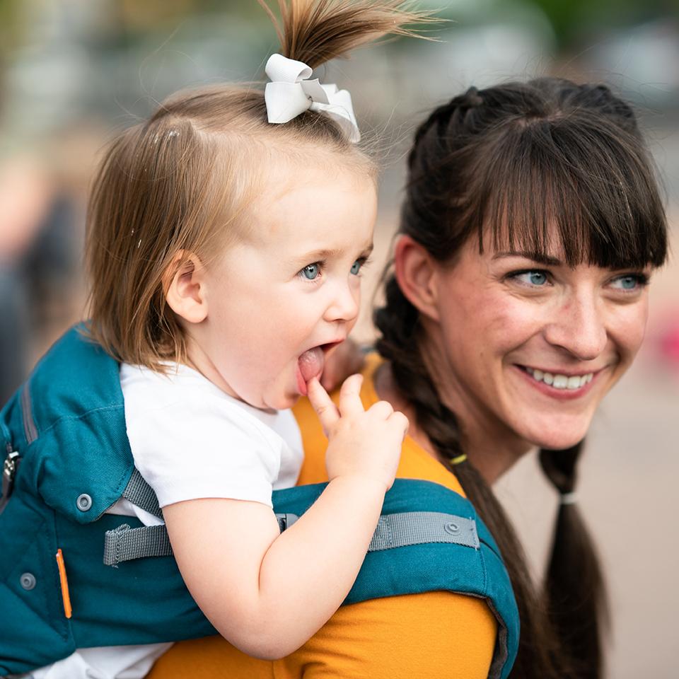 Beco 8 carrier in teal with a baby in back carry position